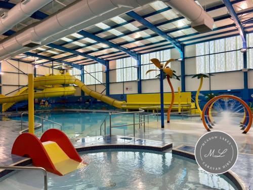 uma piscina com escorrega num parque aquático em Golden Palm Resort - Palm Grove 1 - PG1 em Chapel Saint Leonards
