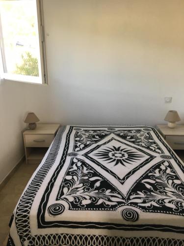 - un lit avec une couverture noire et blanche dans l'établissement Appartement proche des plus belles plages, à Porto-Vecchio