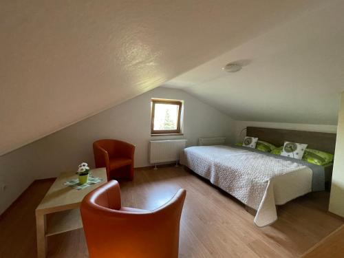 a bedroom with a bed and a table and chairs at Penzión Pod Guglom in Mlynky 