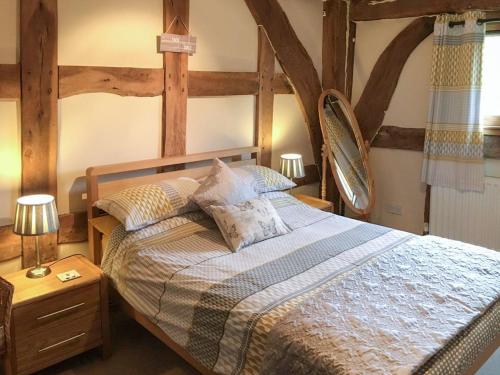 a bedroom with a large bed with a wooden frame at The Granary in Kingsland