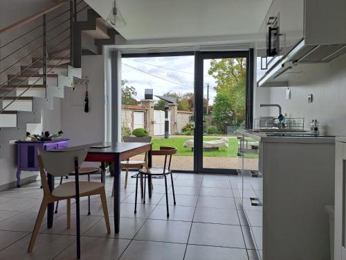 une cuisine et une salle à manger avec une table et des chaises dans l'établissement Gite Dans Parc De Sculptures - Gîte 