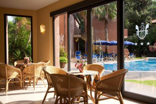 a patio with tables and chairs and a pool at Hotel Venezia in Marina di Pietrasanta