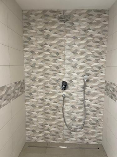 y baño con ducha y pared de piedra. en Ferienwohnung AS Verwaltungs GmbH, en Schopfloch