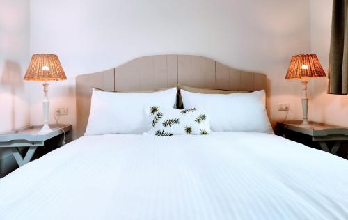 ein Schlafzimmer mit einem weißen Bett mit zwei Lampen in der Unterkunft Il Cortiletto - Suites & Apartments in Pistoia