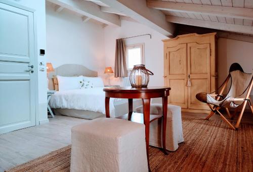 a bedroom with a bed and a table and a chair at Il Cortiletto - Suites & Apartments in Pistoia