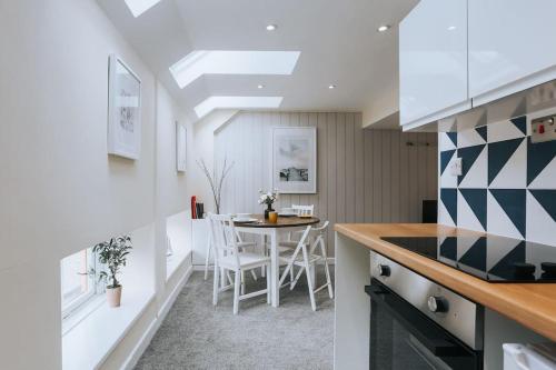 a kitchen and dining room with a table and chairs at The Lighthouse, Boutique apartment in the town centre in Tavistock