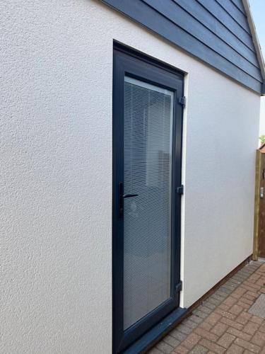 a door with a window on the side of a building at Modern Spacious Annex -Ground Floor in Brightlingsea