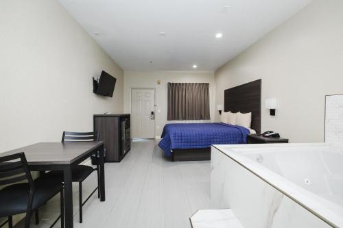a hotel room with a bed and a table at Winchester Inn and Suites Humble/IAH/North Houston in Humble