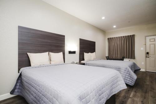 a hotel room with two beds and a window at Winchester Inn and Suites Humble/IAH/North Houston in Humble