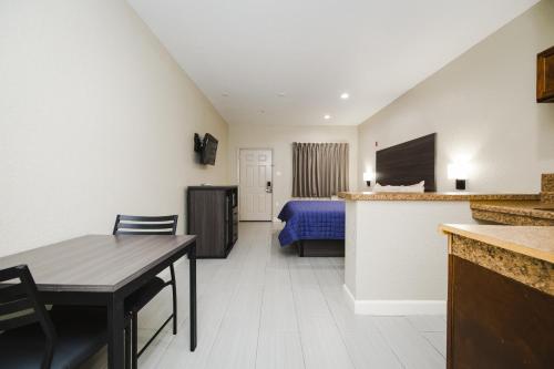 a living room with a table and a bedroom at Winchester Inn and Suites Humble/IAH/North Houston in Humble