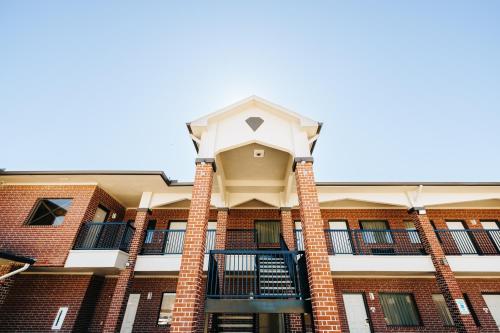 a building with a balcony on the front of it at Winchester Inn and Suites Humble/IAH/North Houston in Humble