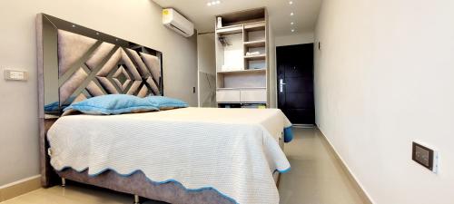 1 dormitorio con 1 cama grande con almohadas azules en 901 Loft con jacuzzi privado cerca al barrio Laureles, en Medellín