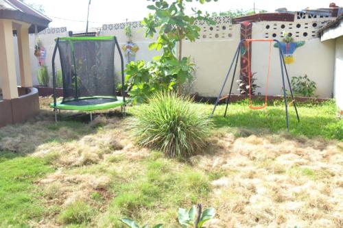 a backyard with a swing set in the yard at Full AirCon- 3Bed Villa- A c- WiFi- HotWater in Freetown