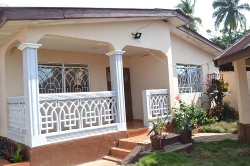 a house with a white balcony and stairs at Full AirCon- 3Bed Villa- A c- WiFi- HotWater in Freetown