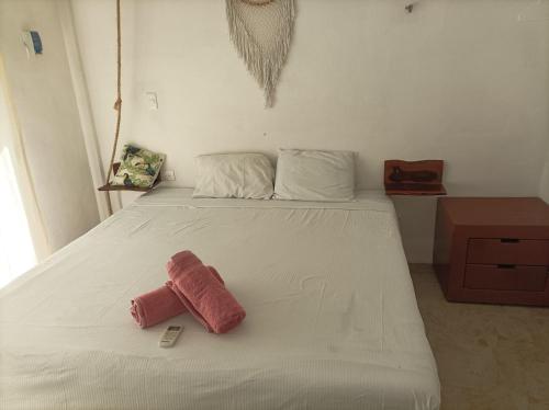 een groot wit bed met een roze handdoek erop bij Costa Esmeralda in El Cuyo