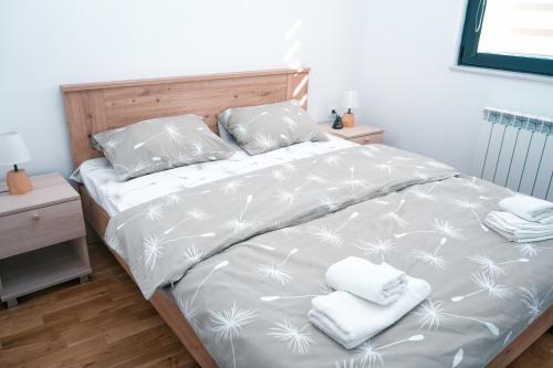 a bedroom with a bed with two towels on it at Sunlight Apartment in Skopje