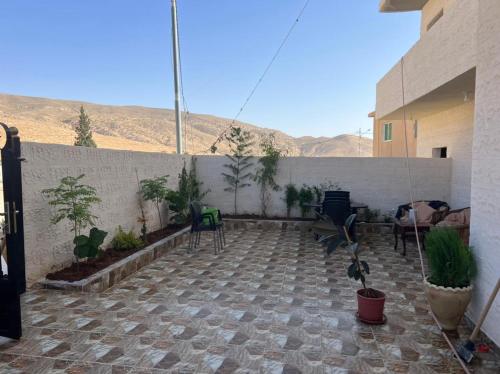 a patio with chairs and plants and a wall at Beida Bedouin House in Al Ḩayy