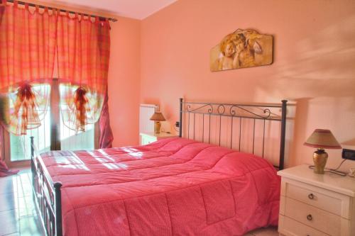 a bedroom with a bed with red sheets and a window at Agriturismo Il Melograno in Tessera