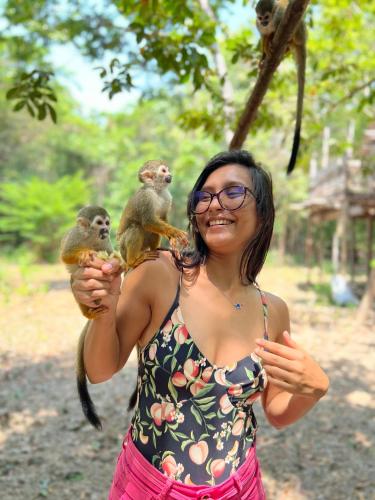a woman holding two monkeys in her hands at Villa Éden in Alter do Chao