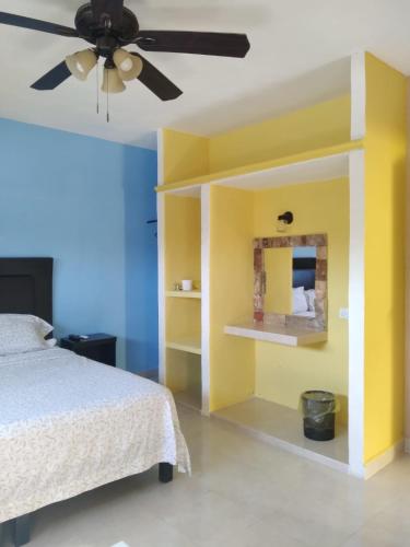 a bedroom with a bed and a ceiling fan at Casa Fernery in Valladolid