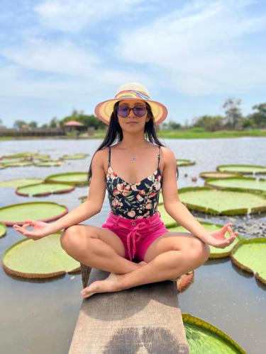 a girl in a hat sitting on a raft in the water at Villa Éden in Alter do Chao