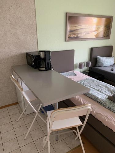 a table and chairs in a room with a bed at Ruhige sonnige Wohnung mit Rooftopterrasse nahe Universität in Gerbrunn