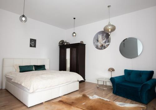 a bedroom with a bed and a blue chair at Old Town Apartment in Poznań