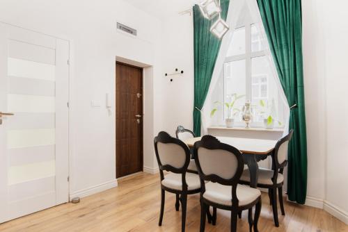 una sala da pranzo con tavolo, sedie e finestra di Old Town Apartment a Poznań