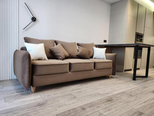 a brown couch in a living room with a table at OASIS-RENT in Chişinău