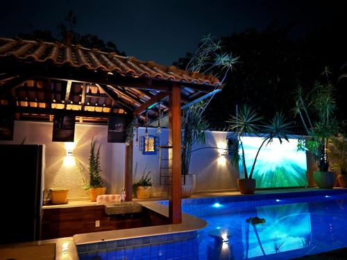 a swimming pool with a pergola at night at Villa Éden in Alter do Chao