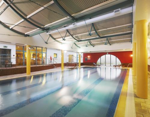 an empty swimming pool in a building with a swimming pool at Ballymascanlon Hotel and Golf Resort in Dundalk