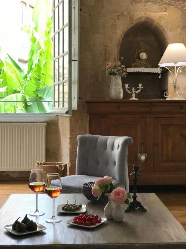 a table with two glasses of wine and a chair at L'appart d'à coté, 2 chambres in Sarlat-la-Canéda