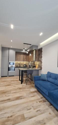 a living room with a blue couch and a kitchen at OASIS-RENT in Chişinău