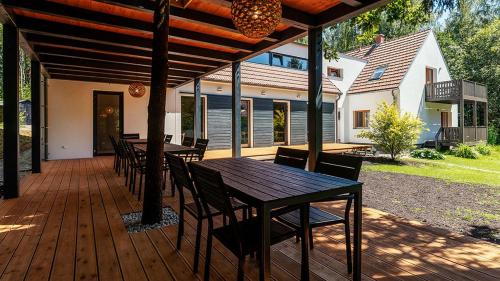 a wooden deck with a table and chairs on it at Penzion Blanko in Nová Bystřice