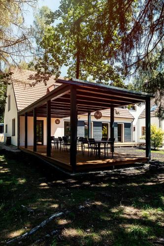 a pavilion with tables and benches in front of a house at Penzion Blanko in Nová Bystřice