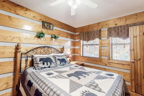 a bedroom with a bed and wooden walls at Dances with Wolves in Pigeon Forge