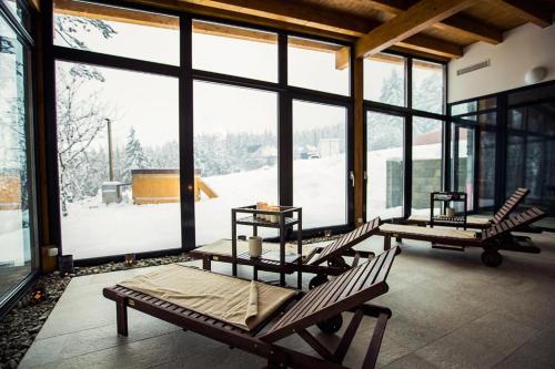 a room with several lounge chairs and a large window at Drevenica Desina in Terchová