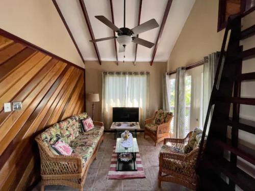 a living room with a couch and a ceiling fan at CentralCity “Paradise” Private Mini Resort & Pool in Belize City