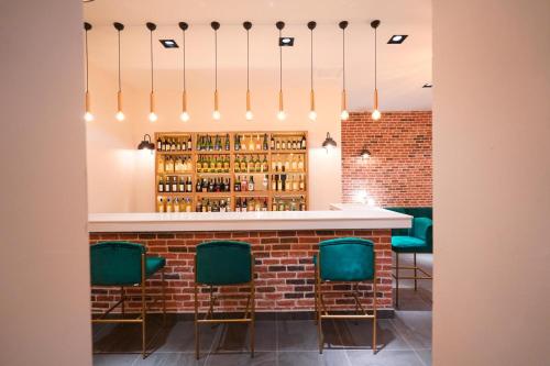 a bar with green chairs and a brick wall at Hotel Amore in Marmaris