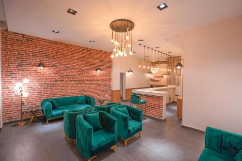 a room with green chairs and a brick wall at Hotel Amore in Marmaris