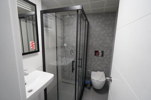 a bathroom with a shower and a toilet and a sink at Hotel Amore in Marmaris