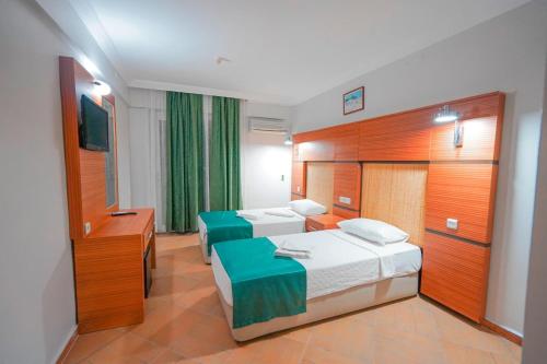 a hotel room with two beds and a desk at Hotel Amore in Marmaris