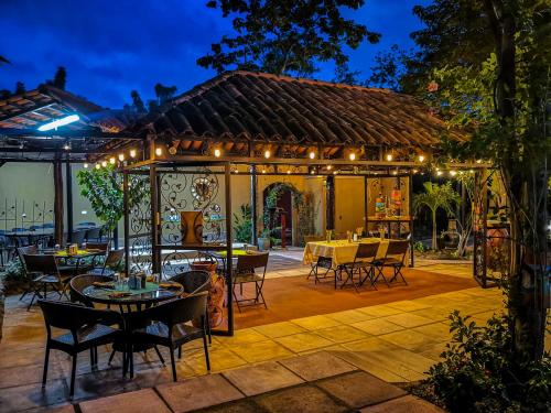 un patio al aire libre con mesas, sillas y luces en Casas del Toro Playa Flamingo, en Playa Flamingo