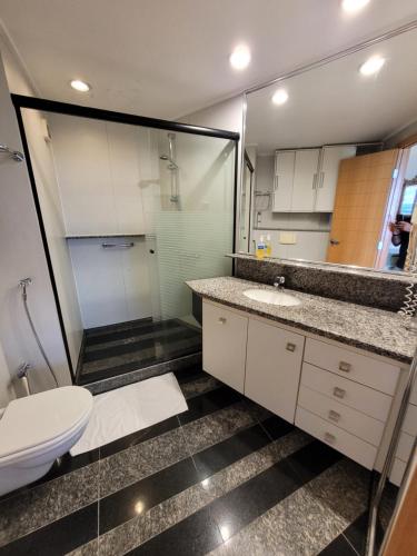 a bathroom with a toilet and a sink and a mirror at Flat - Golden By Rei dos Flats in Brasilia