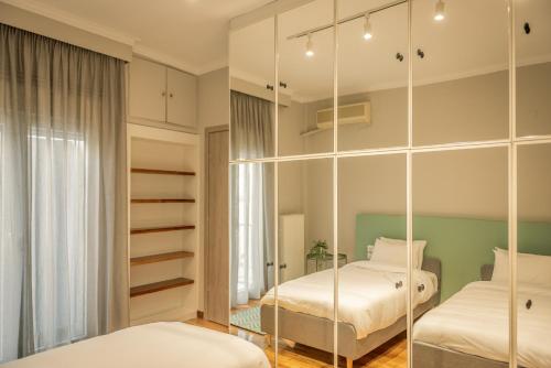 1 Schlafzimmer mit 2 Betten und einem Spiegel in der Unterkunft Hermes Apartment on Aristotelous Midas Home in Thessaloniki