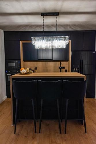 a kitchen with a bar with chairs and a chandelier at Moonlight Hill Point in Deal
