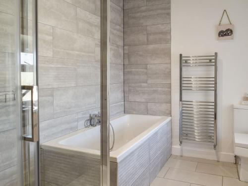 a bathroom with a bath tub and a shower at Llwyn Yr Arth in Llanbabo