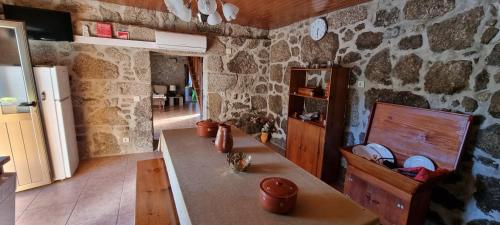 a kitchen with a counter and a stone wall at Casa de Férias V6 com piscina in Ponte de Lima
