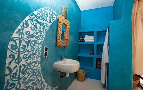a bathroom with a sink and a blue wall at Aghmat Lodge Guest house in Marrakech