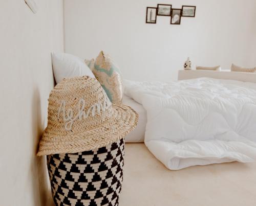 a straw hat sitting on the floor next to a bed at Aghmat Lodge Guest house in Marrakech